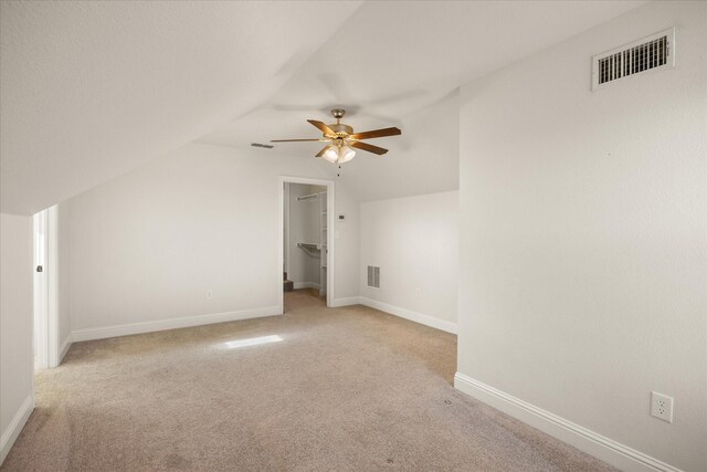 additional living space with light carpet, vaulted ceiling, and ceiling fan