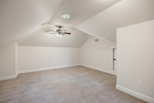 additional living space with ceiling fan, lofted ceiling, and light carpet