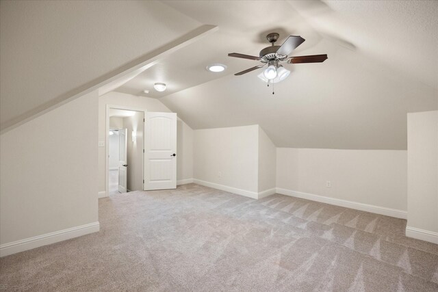 bonus room with light carpet, vaulted ceiling, and ceiling fan