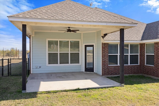 rear view of property featuring a lawn, ceiling fan, and a patio