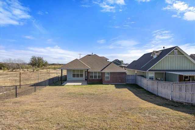 rear view of property with a lawn and a patio