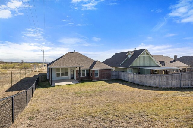 rear view of house with a patio area and a yard