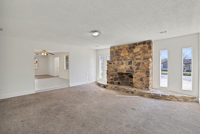 unfurnished living room with ceiling fan, carpet floors, and a textured ceiling