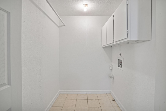 washroom with cabinets, light tile patterned floors, hookup for a washing machine, electric dryer hookup, and a textured ceiling