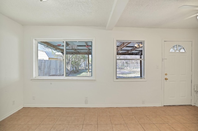 tiled foyer entrance featuring beam ceiling and a textured ceiling