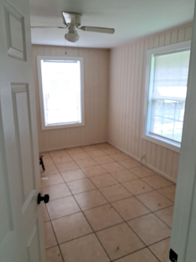 tiled spare room with ceiling fan