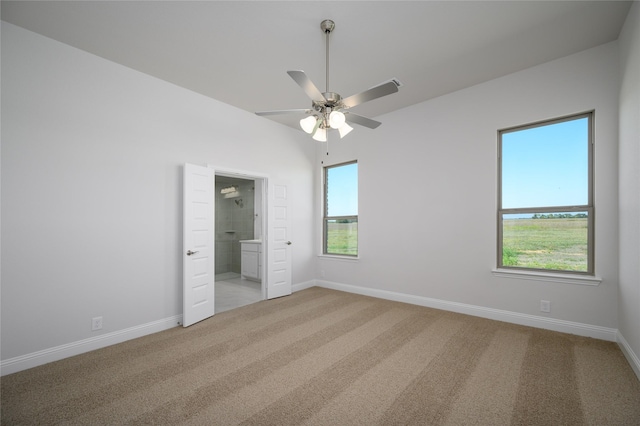 unfurnished bedroom with light carpet, connected bathroom, and ceiling fan