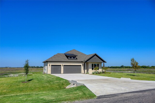 view of front facade featuring a rural view, a garage, and a front lawn