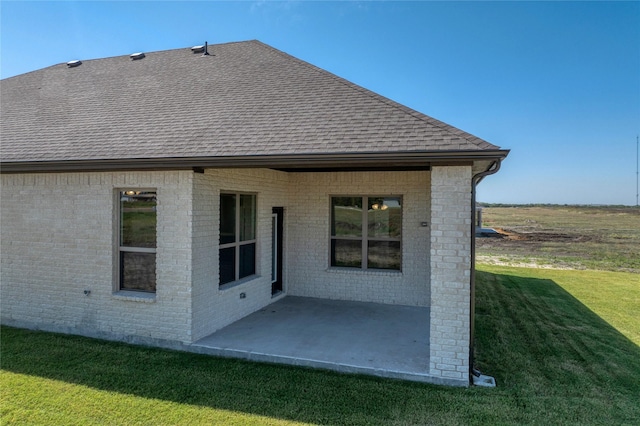 back of property featuring a patio and a lawn