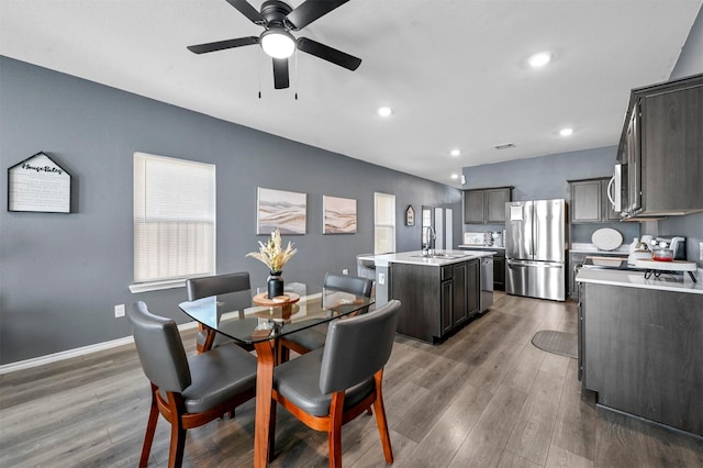 dining room with ceiling fan, a wealth of natural light, dark wood-type flooring, and sink