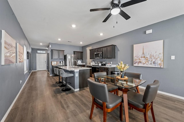 dining area featuring ceiling fan, dark hardwood / wood-style flooring, and sink