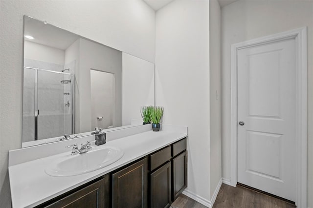 bathroom featuring toilet, vanity, an enclosed shower, and hardwood / wood-style flooring