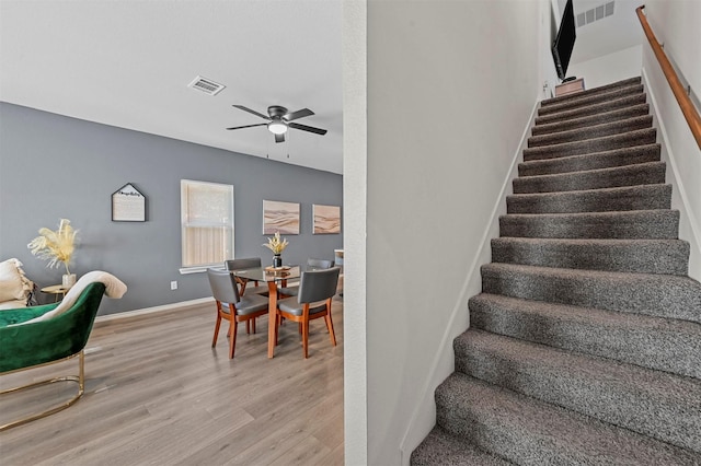 stairway featuring wood-type flooring and ceiling fan