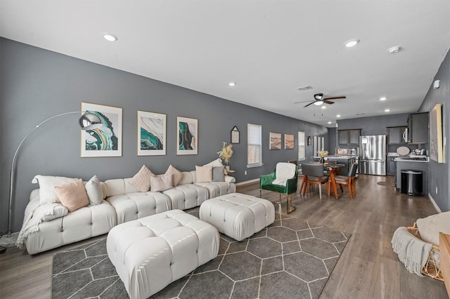 living room featuring ceiling fan and dark hardwood / wood-style flooring