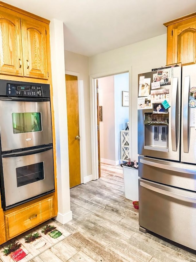 kitchen with appliances with stainless steel finishes and light wood-type flooring