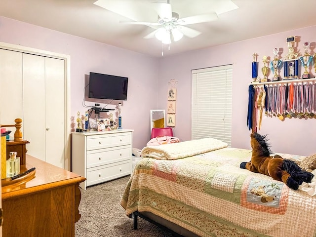 carpeted bedroom with ceiling fan and a closet