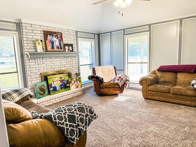 carpeted living room with a brick fireplace, high vaulted ceiling, and ceiling fan