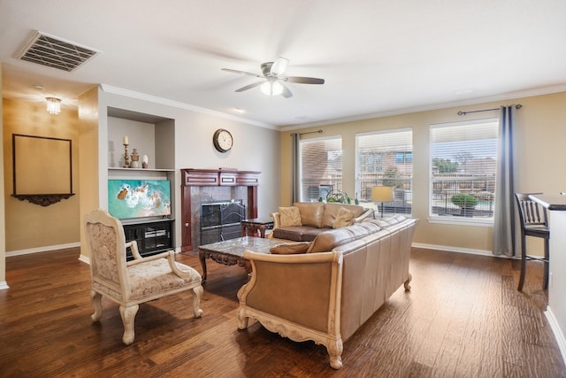 living room with a tiled fireplace, ceiling fan, dark hardwood / wood-style floors, and ornamental molding