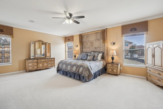 carpeted bedroom featuring ceiling fan and crown molding