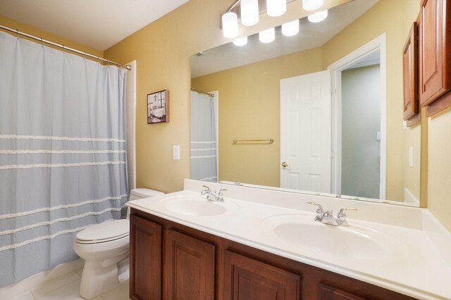 bathroom with tile patterned flooring, vanity, and toilet