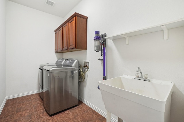 clothes washing area with cabinets, independent washer and dryer, and sink