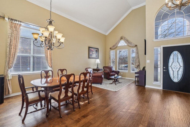 dining area featuring a chandelier, plenty of natural light, ornamental molding, and vaulted ceiling