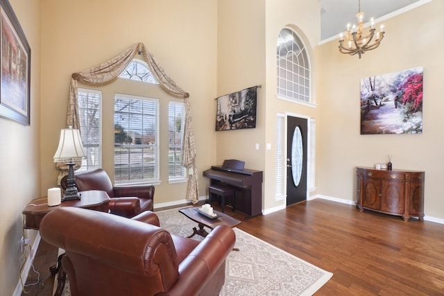 living room featuring a high ceiling, dark wood-type flooring, and a notable chandelier