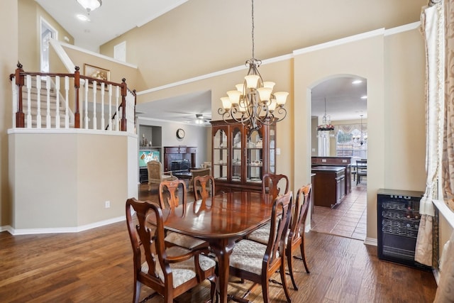 dining room featuring ceiling fan with notable chandelier, heating unit, crown molding, and dark wood-type flooring