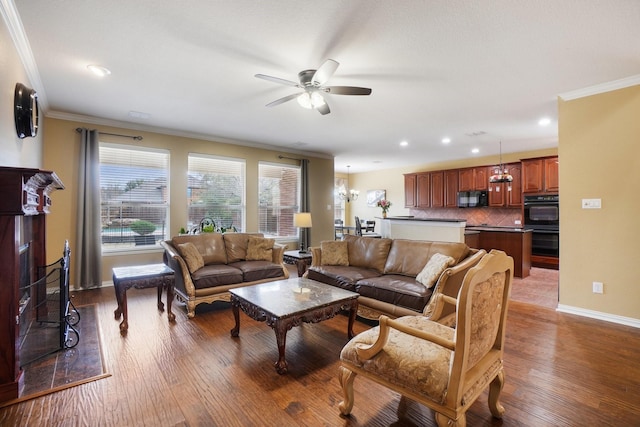 living room featuring wood-type flooring, ceiling fan with notable chandelier, and crown molding