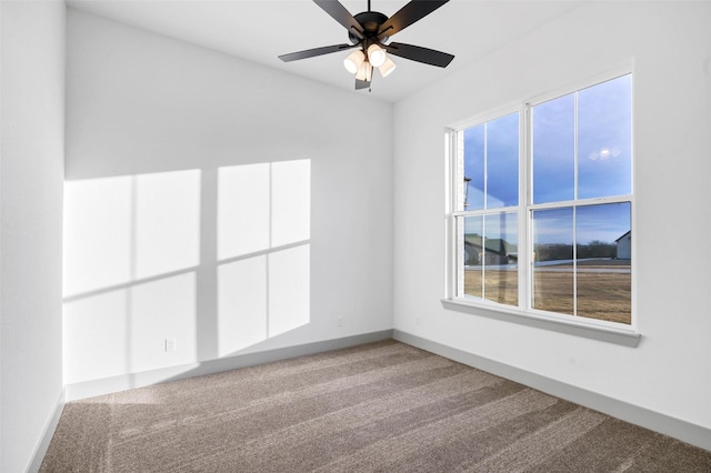 carpeted spare room featuring ceiling fan