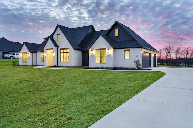 modern farmhouse style home featuring a yard and a garage