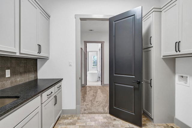 kitchen with backsplash and dark stone counters