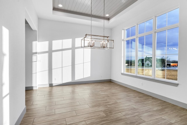 unfurnished dining area featuring a tray ceiling and light hardwood / wood-style flooring