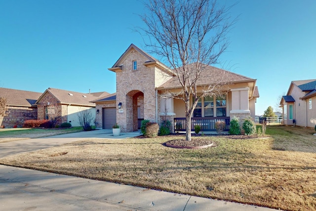 view of front of property with covered porch, a garage, and a front lawn