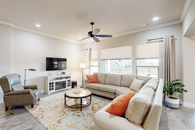 living room featuring crown molding, hardwood / wood-style floors, and ceiling fan