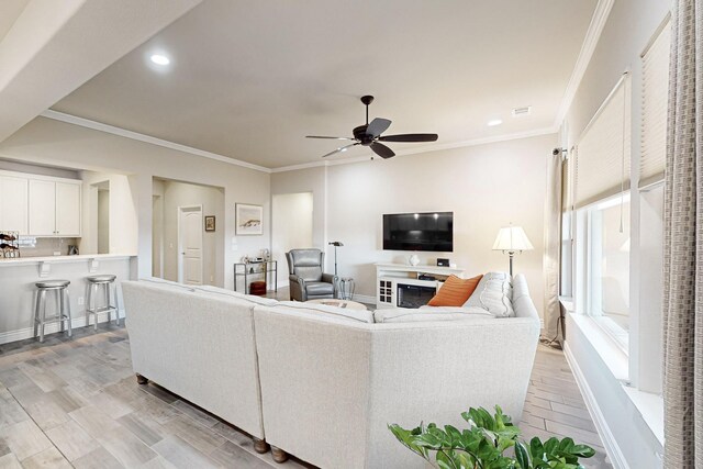 living room with ceiling fan and crown molding