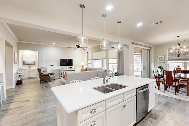 kitchen featuring sink, stainless steel dishwasher, an island with sink, decorative light fixtures, and white cabinets