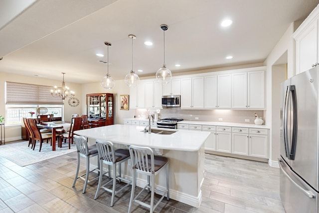 kitchen featuring white cabinets, pendant lighting, stainless steel appliances, and sink