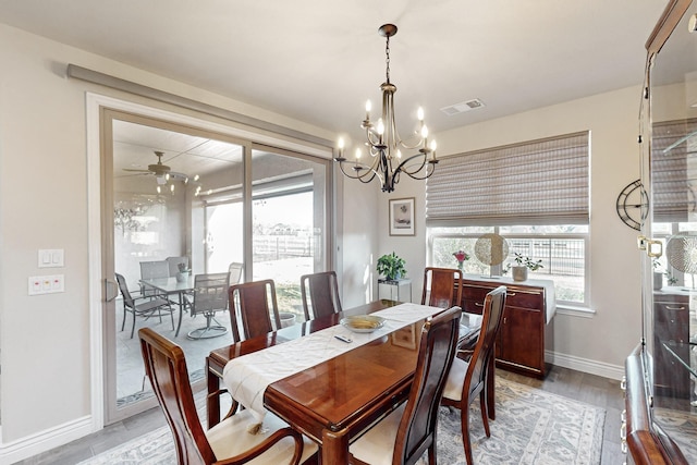 dining room with ceiling fan with notable chandelier and light wood-type flooring