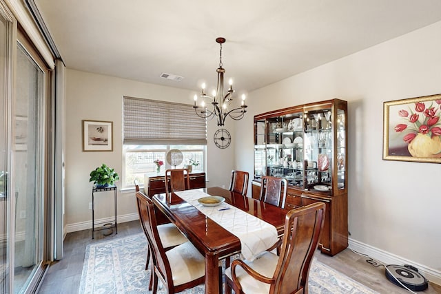 dining room featuring a notable chandelier and light wood-type flooring