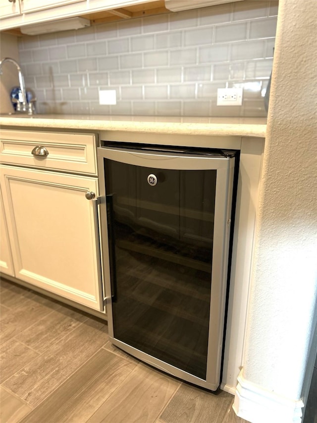 room details featuring decorative backsplash, sink, and wine cooler