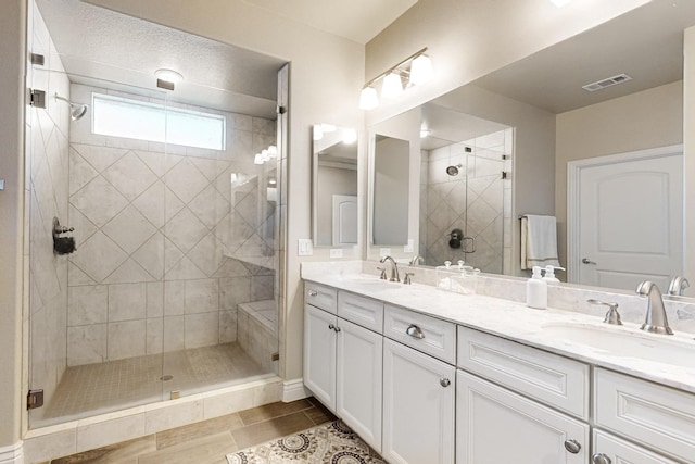 bathroom featuring tile patterned flooring, vanity, and walk in shower