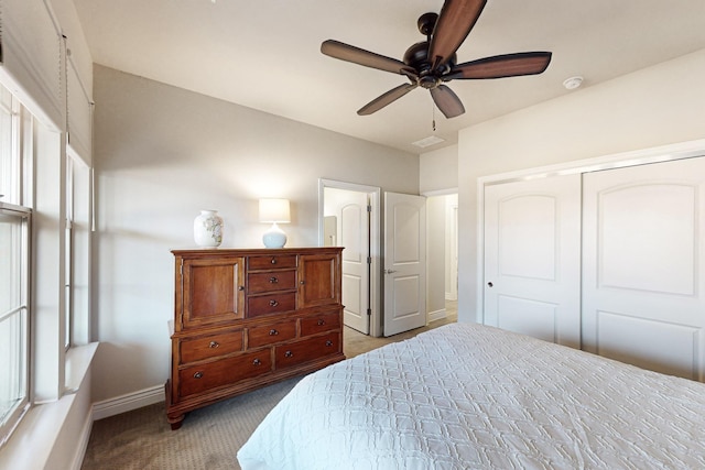 bedroom with a closet, ceiling fan, and light colored carpet