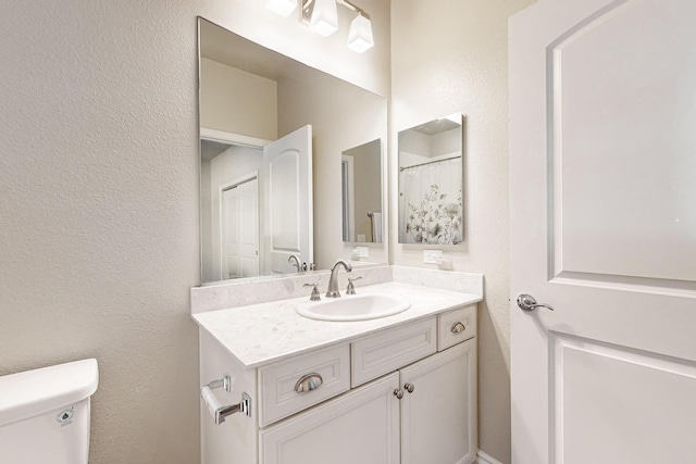 bathroom featuring vanity and toilet