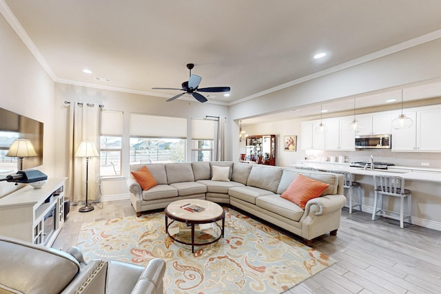 living room featuring ceiling fan, light hardwood / wood-style floors, and ornamental molding