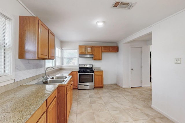 kitchen with stainless steel range oven, ornamental molding, sink, and light tile patterned floors