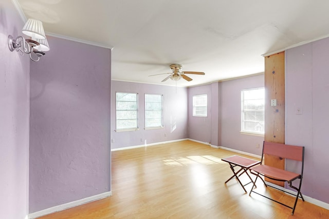 interior space with light wood-type flooring, plenty of natural light, ceiling fan, and crown molding