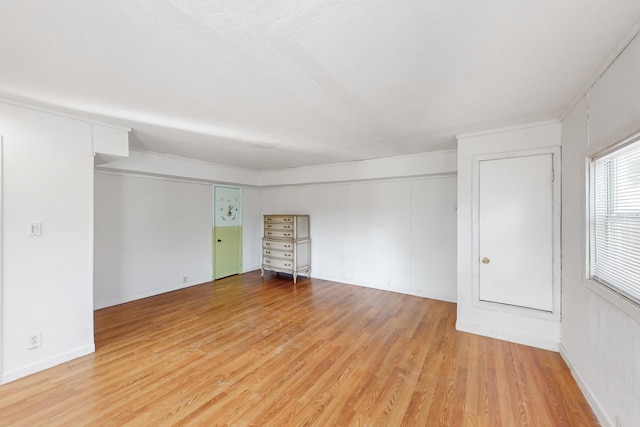 empty room with light hardwood / wood-style floors and a textured ceiling