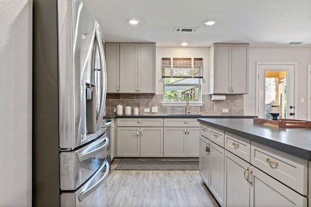 1813 Aslynn Cir, Aubrey, TX 76227 - kitchen with stainless steel fridge, a sink, dark countertops, light wood finished floors, and recessed lighting