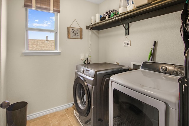 laundry area featuring light tile patterned floors and washing machine and dryer